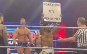 Roman Reigns Reacts To Fan Sign Saying He Sits When He Pees